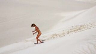 using a snow board on a sand dune